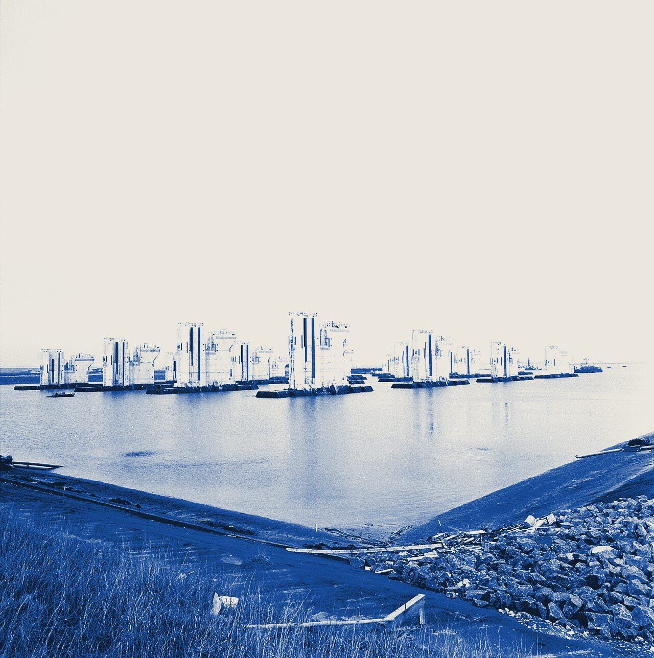 De pijlers van de Oosterscheldekering staan als een spookstad in het water